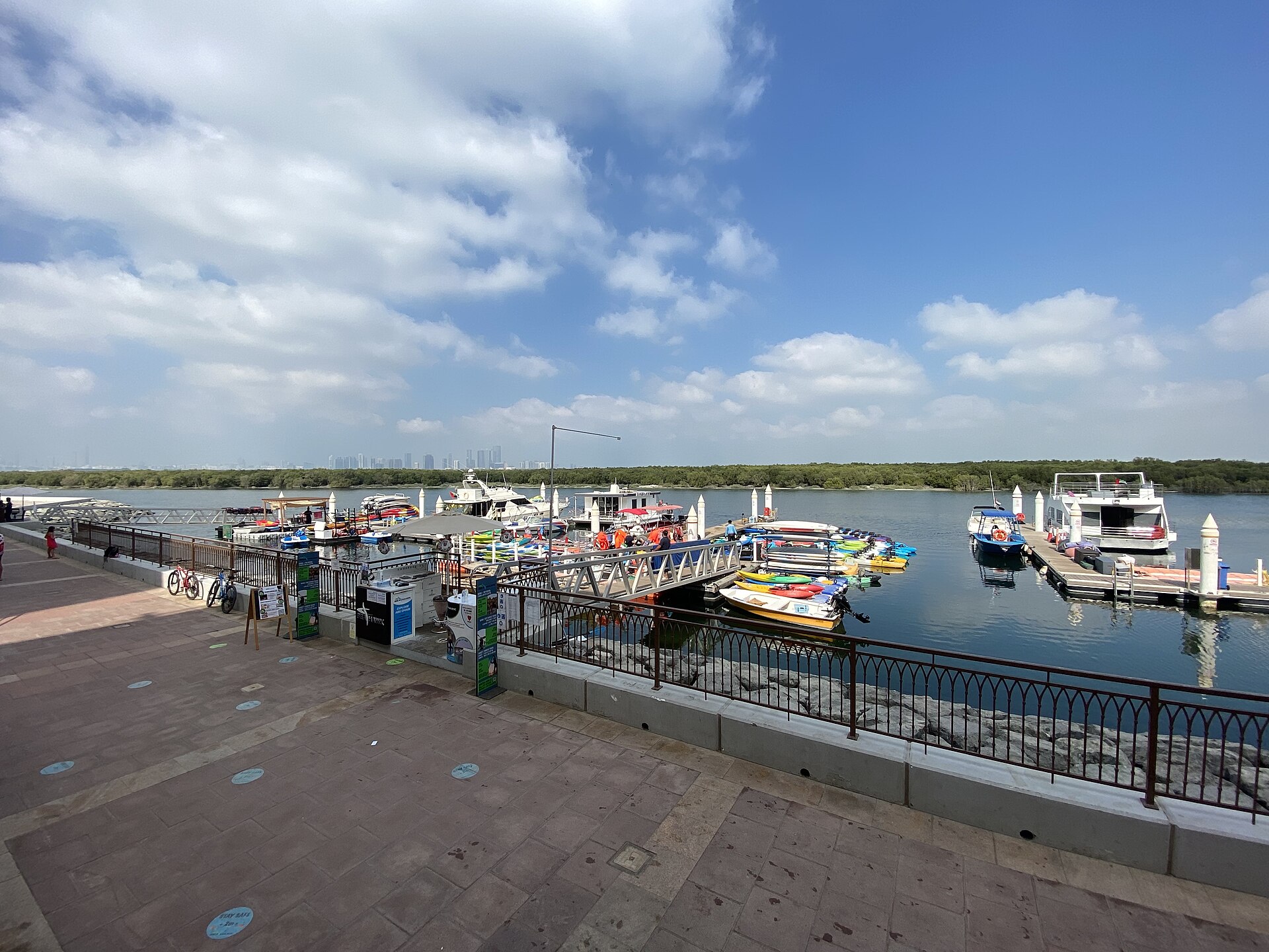 Eastern Mangroves boardwalk and small marina with kayaks under a partly cloudy sky