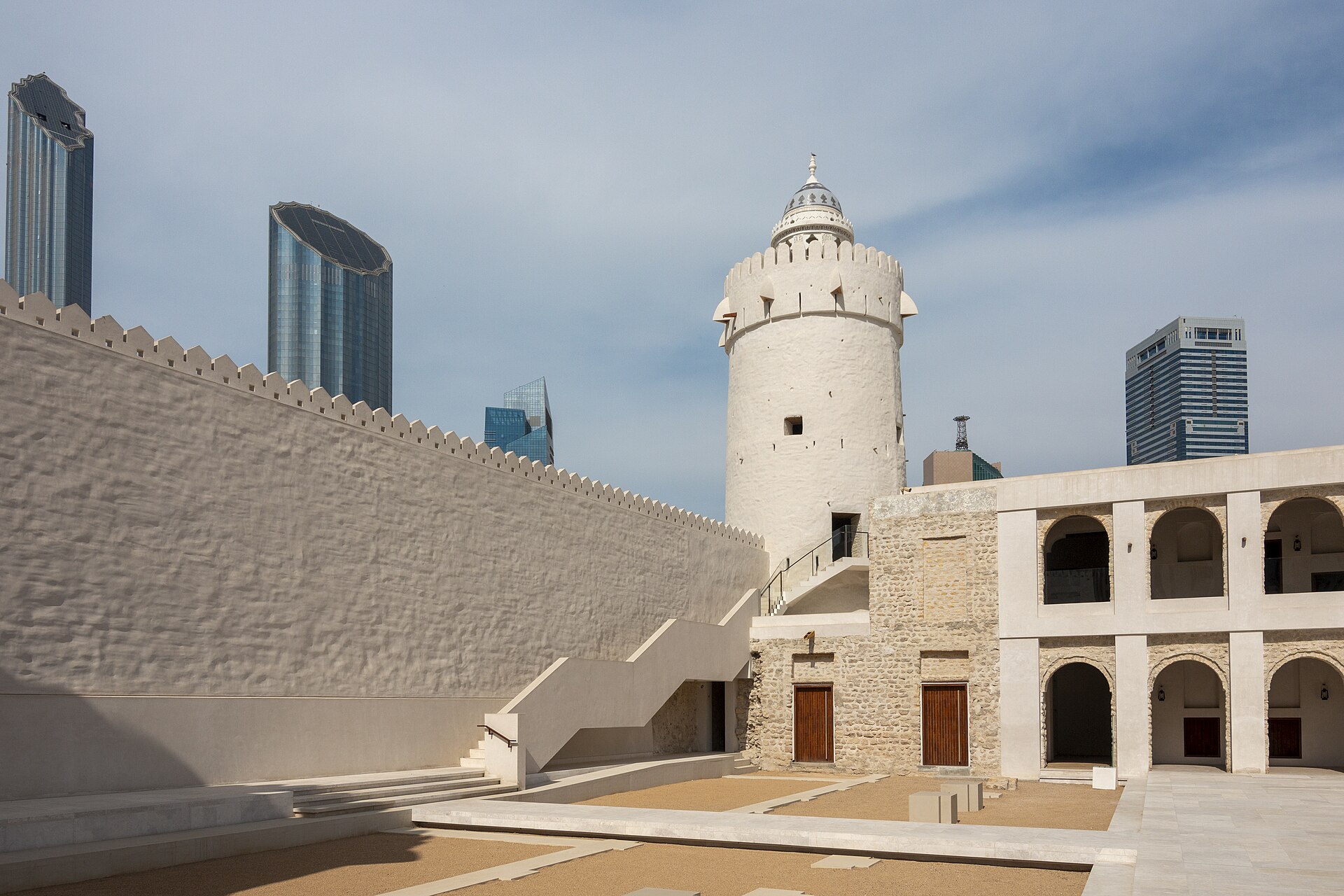 The white watchtower of Qasr Al Hosn fort with modern Abu Dhabi skyscrapers behind
